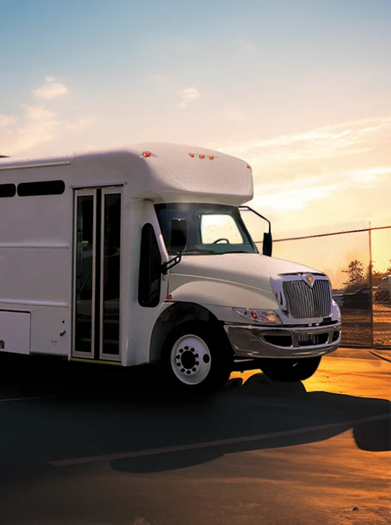 White shuttle bus parked next to a security fence at a prison near New Orleans